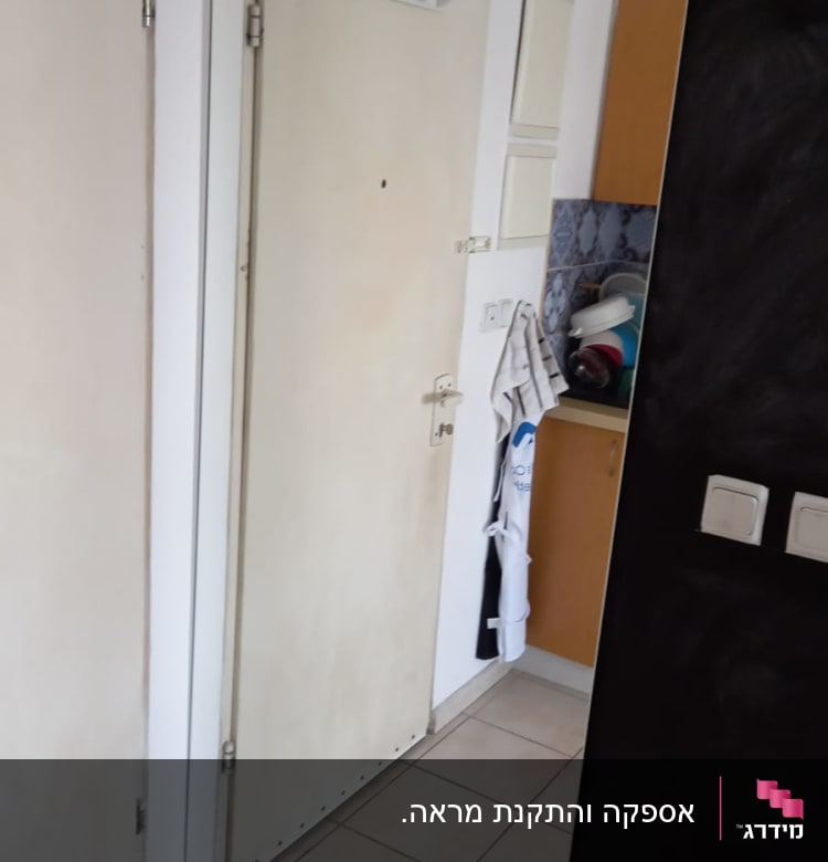 מראה גדולה על קיר ליד דלת כניסה